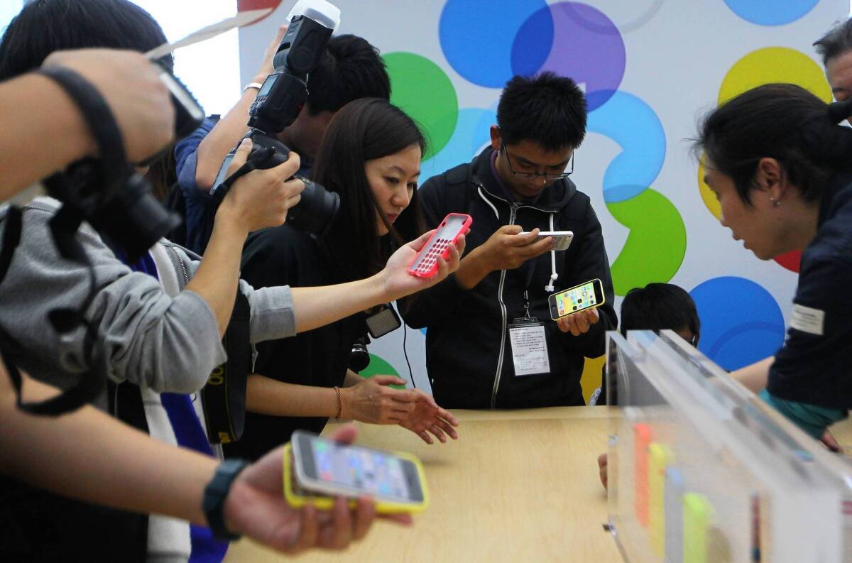 With Apple’s overall growth slowing, investors and analysts believe that Apple’s best opportunity to supercharge its growth is to become more competitive in newer markets. Above, journalists look at newly released Apple products during an Apple press conference in Beijing on Wednesday.