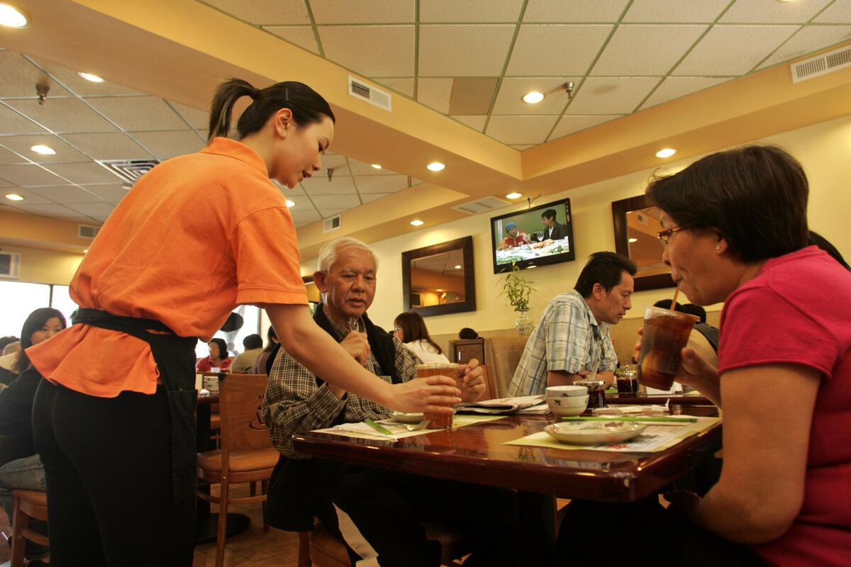 Annie Yu serves herbal tea at Tasty Garden restaurant in Alhambra, one of Jonathan Gold's top SGV restaurants with "tasty" in the name.
