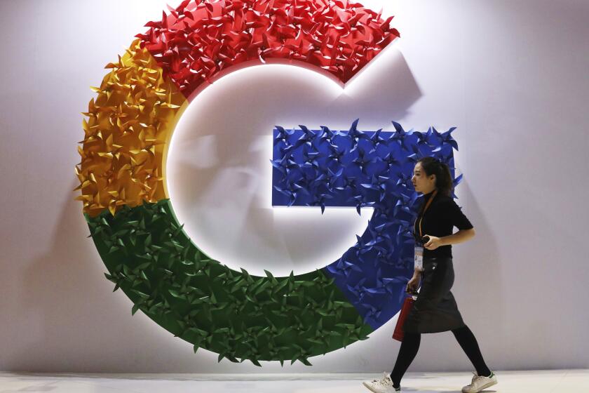 FILE - A woman walks past the logo for Google at the China International Import Expo in Shanghai, Monday, Nov. 5, 2018. A top European Union court rejected on Wednesday, Nov. 9, 2021 Google's appeal against a 2.4 billion euro ($2.8 billion) antitrust penalty from the bloc's competition watchdog, which found the company abused its dominant position by giving its shopping service an illegal advantage. (AP Photo/Ng Han Guan, File)