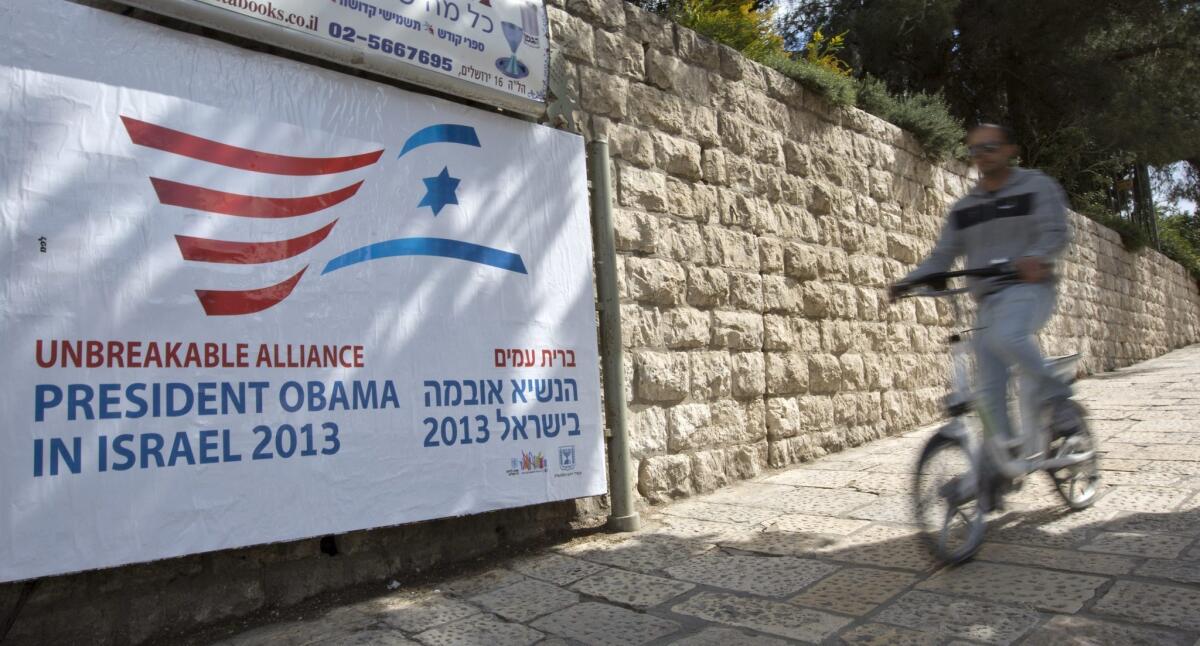 A cyclist passes a billboard near the hotel where President Obama will be staying in Jerusalem, when he arrives on March 20 for his two-day visit.