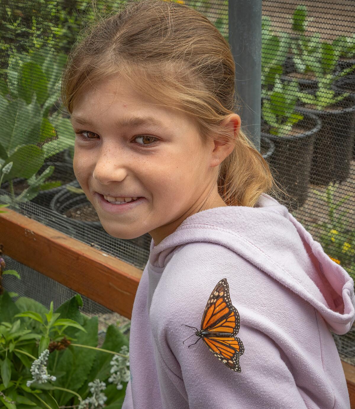 A monarch butterfly lands on the shoulder of visitor Ava Kachkovsky, 10, of San Diego.