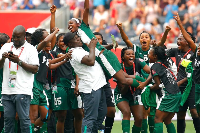 Ngozi Okobi is lifted by a coach and teammates after she was selected player of the match following a 3-3 tie with Sweden in group play of the Women's World Cup on June 8.