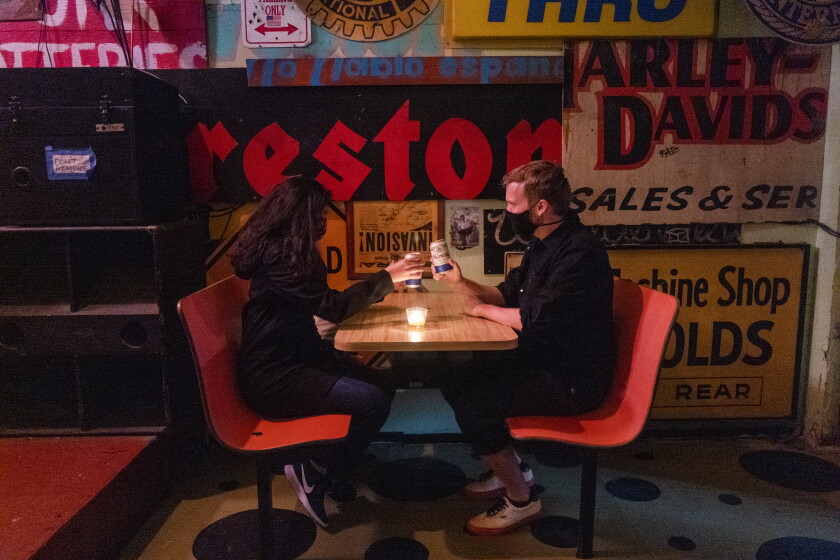 California nears COVID-19 vaccine target that would ease
more reopening rules 2 LOS ANGELES, CA - APRIL 02: Jasmine Aguilar, left, and Adam Ziegenhals, right, both of Echo Park, stop in for a beer inside the empty Ham & Eggs Tavern on Friday, April 2, 2021 in Los Angeles, CA. They are the only customers. During the on going global pandemic Los Angeles is preparing to allow bars that don't serve food to re open. (Francine Orr / Los Angeles Times)