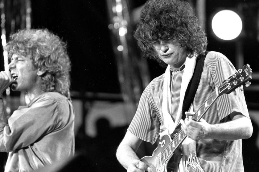 Singer Robert Plant, left, and guitarist Jimmy Page of the British rock band Led Zeppelin perform at the Live Aid concert at Philadelphia's J.F.K. Stadium on July 13, 1985.