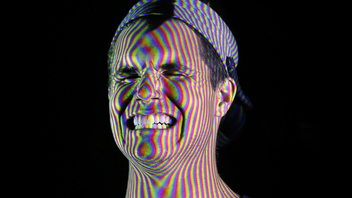 Actor Robbie Amell holds a variety of facial expressions while projectors shoot light patterns on his face to build the first level of geometry to create his digital double.