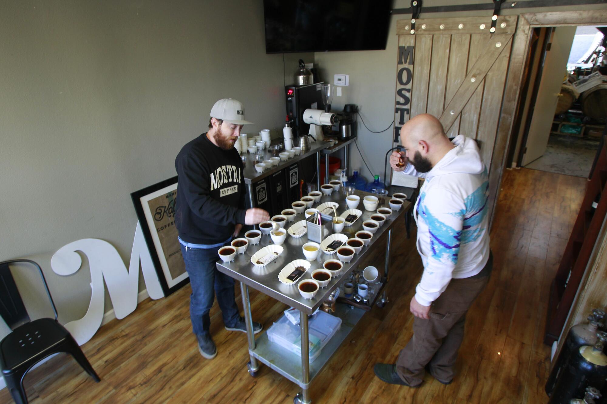Head roaster Nick Berardi (right) and director of coffee Ryan Sullivan taste test different coffees at the Mostra roasting facility.