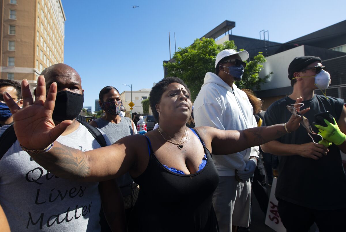 Patrisse Cullors marches with her arms extended during a Hollywood Black Lives Matter protest