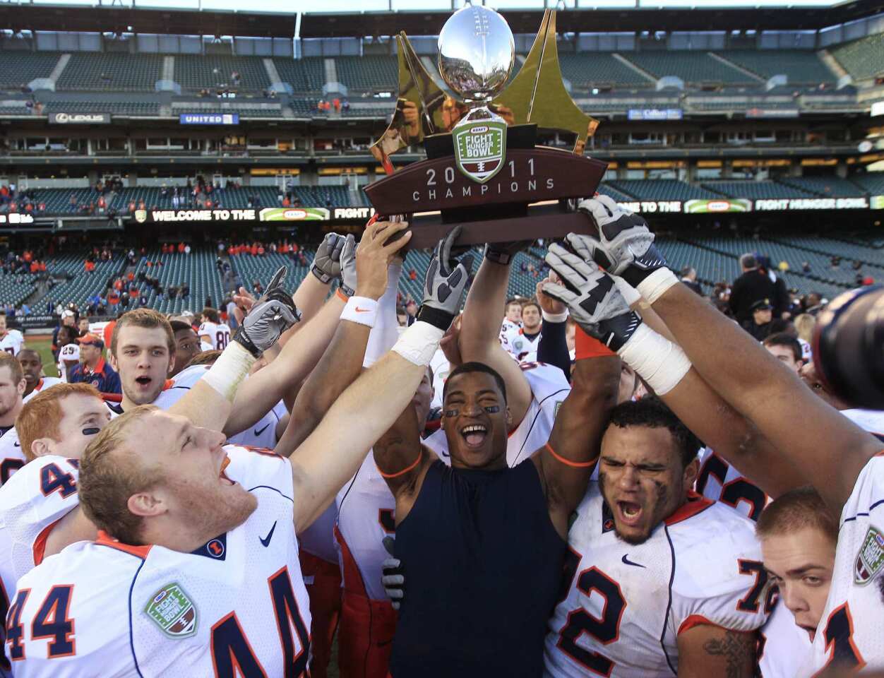 Illinois players hold aloft the Kraft Fight Hunger Bowl trophy after defeating UCLA, 20-14, on Saturday afternoon at AT&T Park in San Francisco.