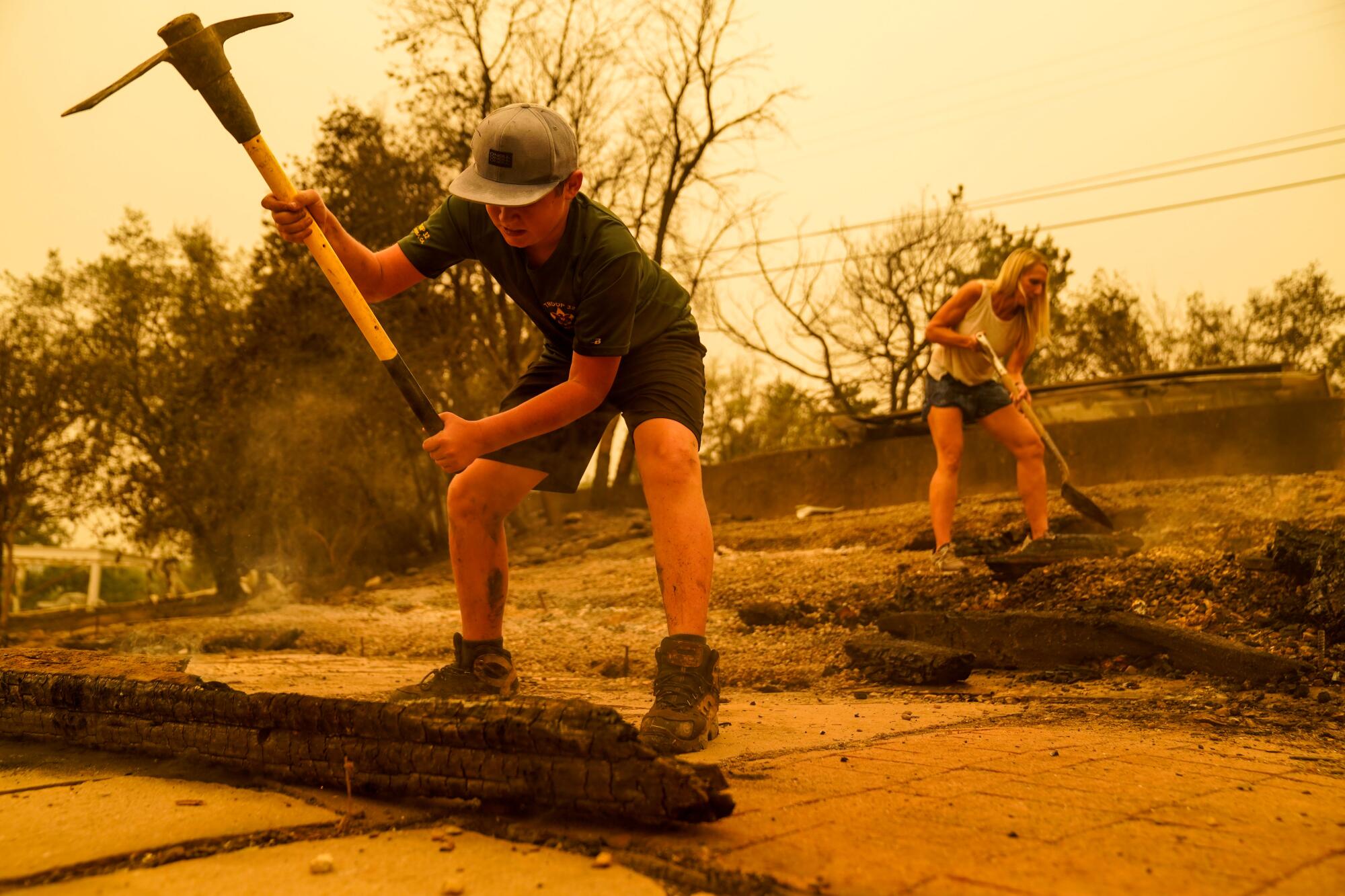 Residents use a pickaxe and a shovel to put out smoldering patches.