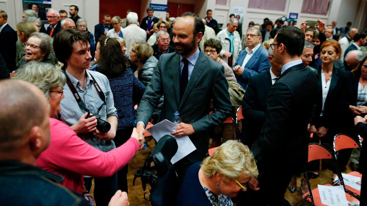 Mayor of Le Havre Edouard Philippe, center, shakes hands after presenting the candidates for the En Marche! party ahead of the France parliament election in June.