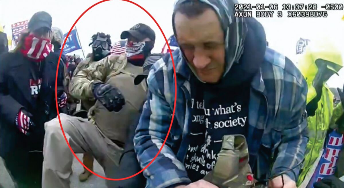 An image from video of Capitol rioters with a circle drawn around one man.