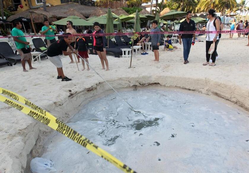Turistas observan un socavón hoy, miércoles 25 de julio de 2018, en Playa del Carmen, en el estado de Quintana Roo (México). Un socavón de cinco metros de ancho y 3 de profundidad se abrió hoy a escasos metros del mar del balneario caribeño de Playa del Carmen, estado mexicano de Quintana Roo, informaron las autoridades locales. EFE