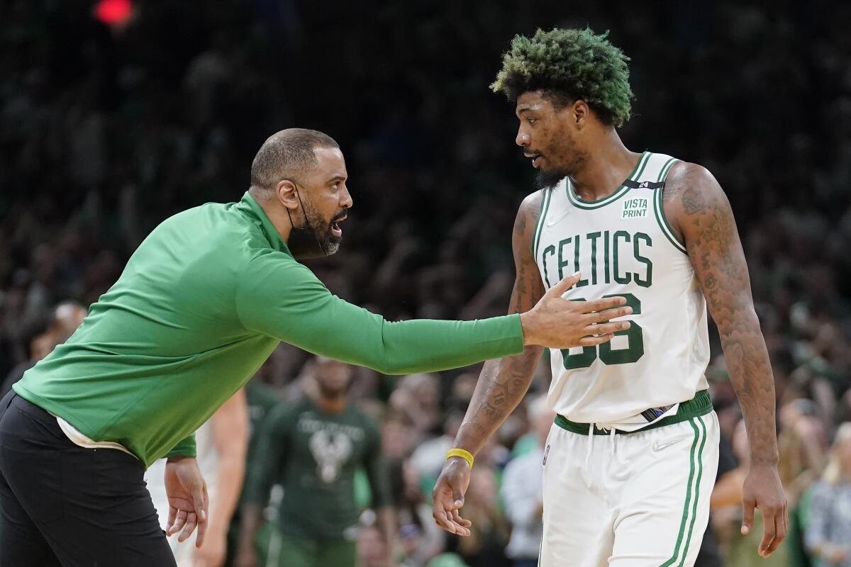 Boston Celtics head coach Ime Udoka, left, speaks with Celtics guard Marcus Smart, right, as the team leads the Milwaukee Bucks during the second half of Game 7 of an NBA basketball Eastern Conference semifinals playoff series, Sunday, May 15, 2022, in Boston. (AP Photo/Steven Senne)