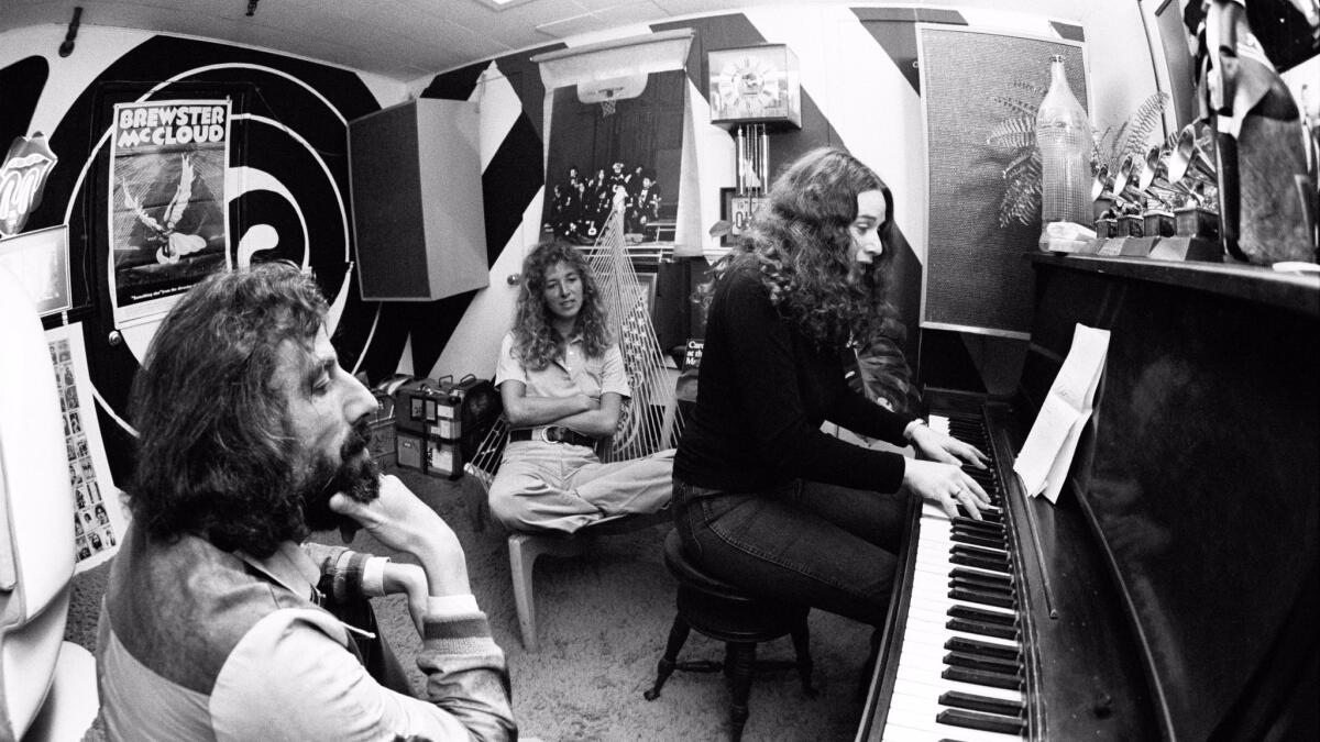 American singer-songwriter Carole King plays the piano to record producer Lou Adler, left, and her co-writer Toni Stern in Lou Adler's office in March 1971 in Los Angeles. (Jim McCrary / Redferns)