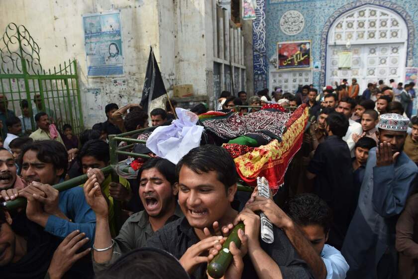Mourners on Feb. 17 carry the coffin of a victim killed in a suicide bombing at a Sufi shrine in Pakistan’s Sindh province.