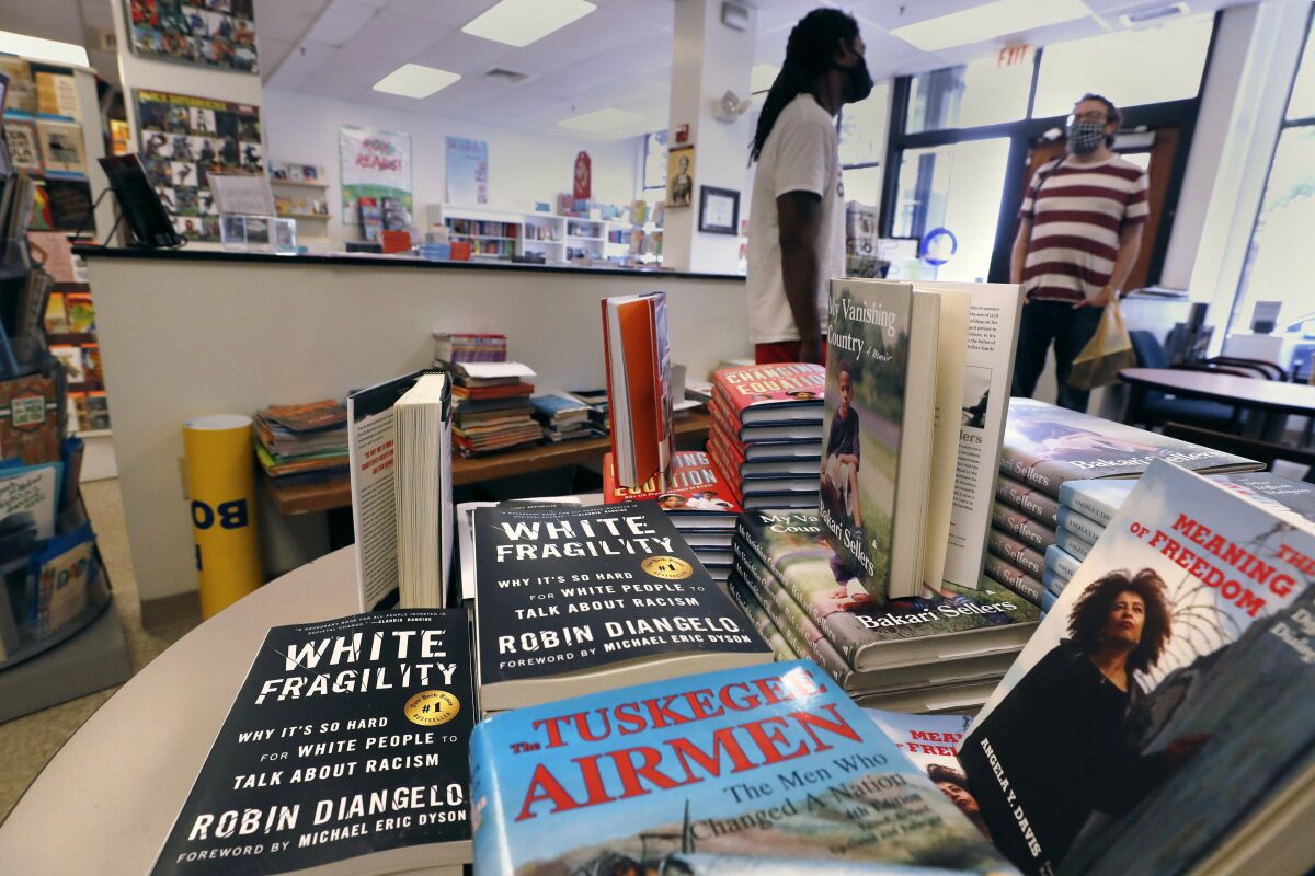 Books are displayed, including "The Tuskegee Airmen," and "White Fragility."
