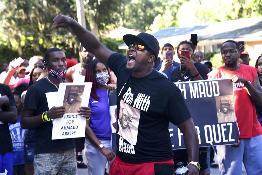 CORRECTS SPELLING OF FIRST NAME TO AHMAUD INSTEAD OF AHMOUD - In this Tuesday, May 5, 2020, photo, Keith Smith speaks to a crowd as they march through a neighborhood in Brunswick, Ga. They were demanding answers regarding the death of Ahmaud Arbery. An outcry over the Feb. 23 shooting of Arbery has intensified after cellphone video that lawyers for Arbery's family say shows him being shot to death by two white men. (Bobby Haven/The Brunswick News via AP)