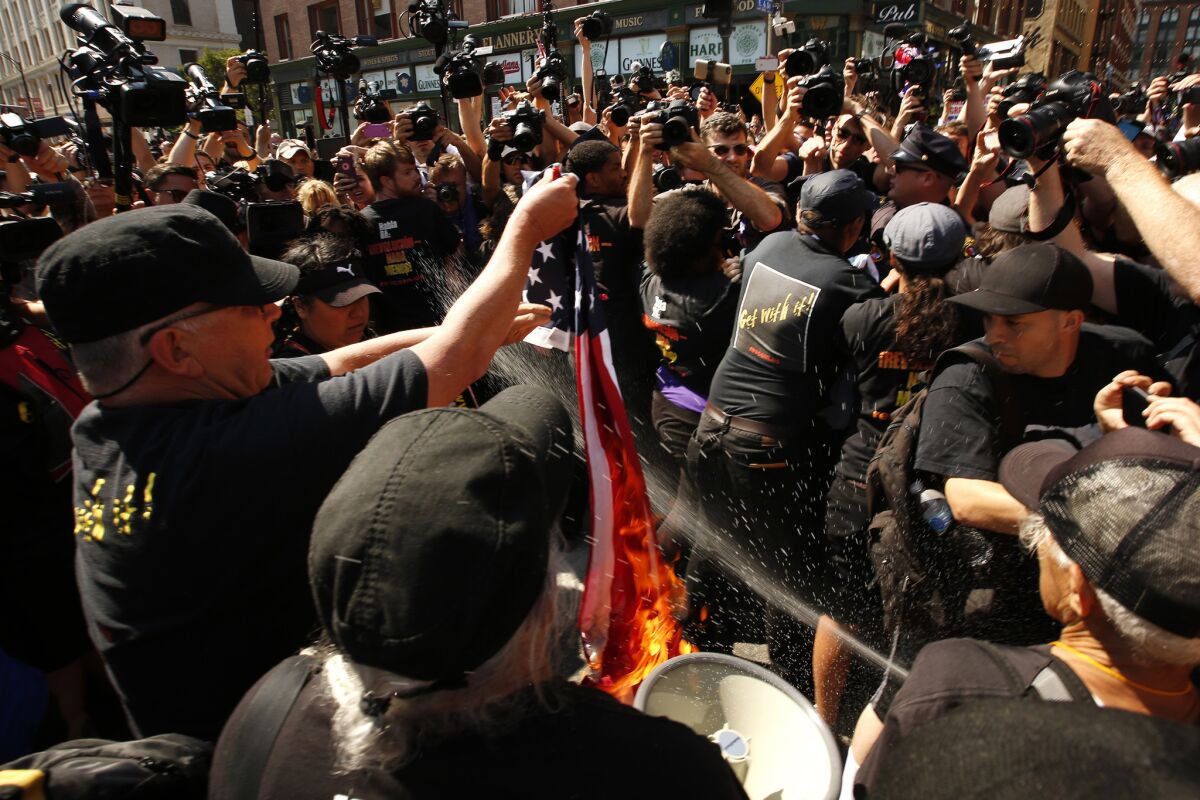 Police arrest protesters from the Revolutionary Communist Party as they burned an American flag. (Carolyn Cole / Los Angeles Times)