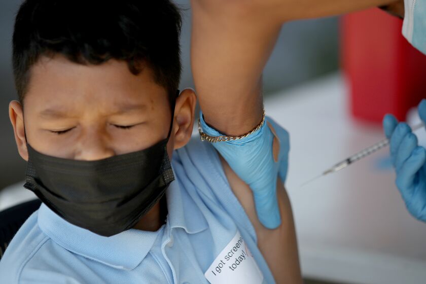 LYNWOOD, CALIF. - MAR. 16, 2022. Paolo Canizales, 10, winces as he gets a shot of the Pfizer vaccine at Hellen Keller Elementary School in Lynwood on Wednesday, Mar. 16, 2022. (Luis Sinco / Los Angeles Times)