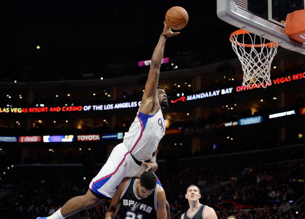 Clippers center DeAndre Jordan attempts a dunk as he elevates above Spurs forward Tim Duncan, who was called for a foul on the play in the first half.