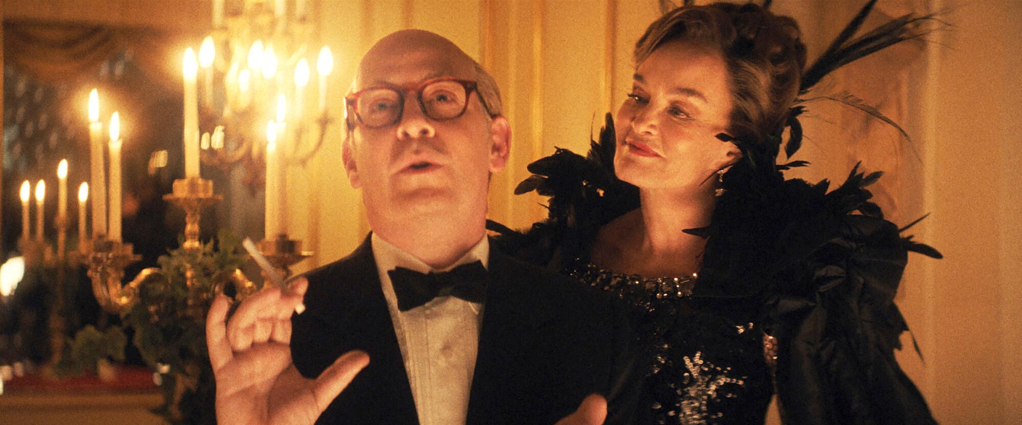 Truman Capote smokes while his mother, in a ballgown behind him, smiles at him in "Feud: Capote vs. the Swans."