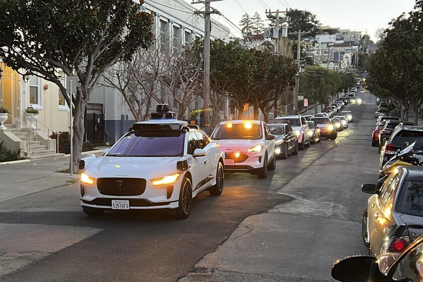 FILE - A Waymo driverless taxi stops on a street in San Francisco for several minutes because the back door was not completely shut, while traffic backs up behind it, on Feb. 15, 2023. California regulators are poised to decide whether two rival robotaxi services can provide around-the-clock rides throughout San Francisco, despite escalating fears about recurring incidents that have cause the driverless vehicles to block traffic or imperil public safety. (AP Photo/Terry Chea, file)