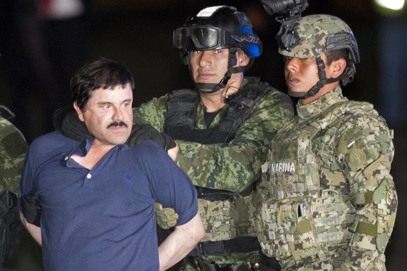 Drug lord Joaquin "El Chapo" Guzman is made to face the press as he is escorted to a helicopter in handcuffs in Mexico City after his recapture in January.