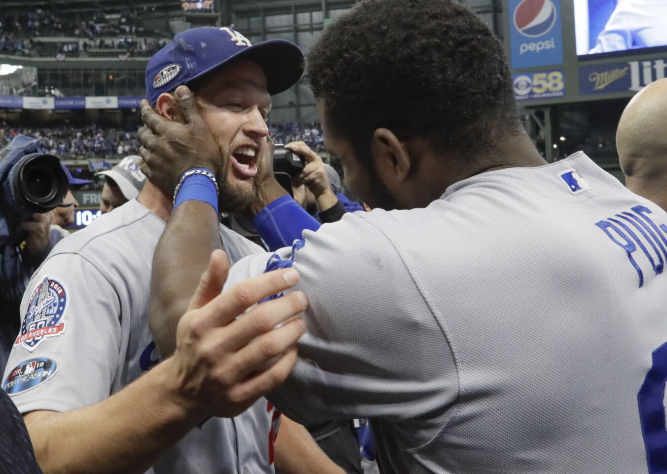 Yasiel Puig and Clayton Kershaw celebrate a 5-1 win over the Brewers in game seven.