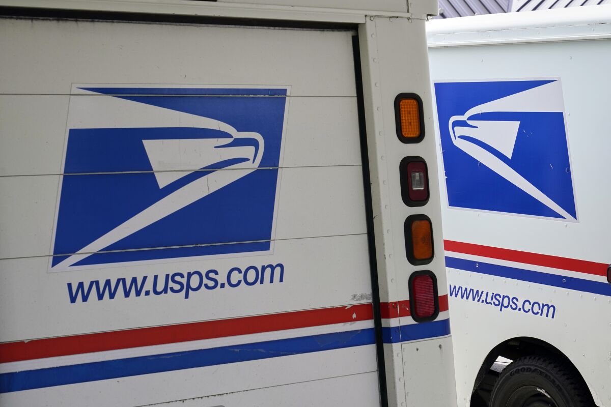 FILE - In this Aug. 18, 2020, photo, mail delivery vehicles are parked outside a post office in Boys Town, Neb. Democrats on the House Oversight Committee are seeking an investigation into a U.S. Postal Service plan to replace its aging mail trucks with mostly gasoline-powered vehicles. (AP Photo/Nati Harnik, File)