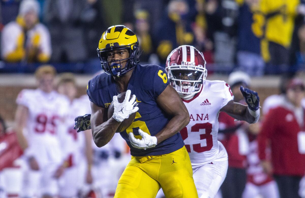 Michigan wide receiver Cornelius Johnson makes a 50-yard reception as Indiana defensive back Jaylin Williams closes in.