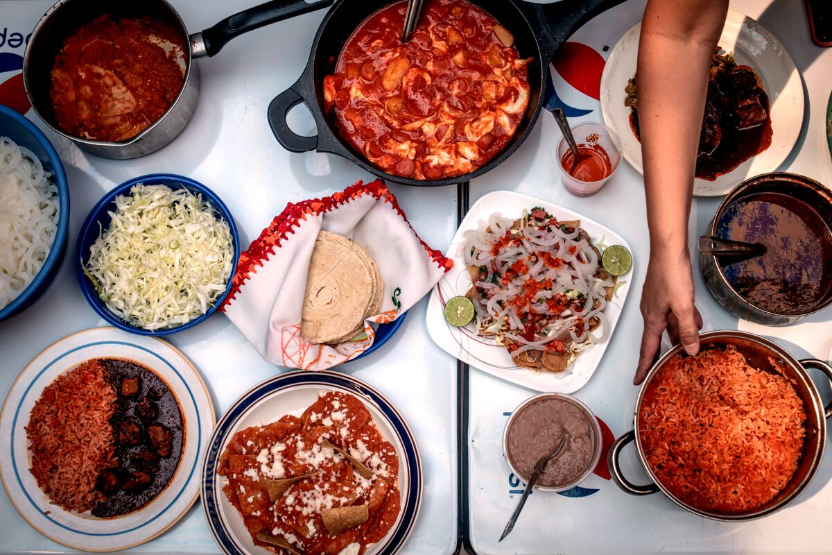 A photo of rice, tortillas, enchiladas and other Mexican dishes on a table. 