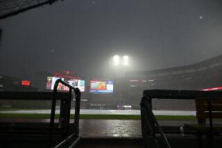 Una lona cubre el campo durante una tormenta en la décima entrada del juego entre los Cardenales de San Luis y los Medias Blancas de Chicago, el sábado 4 de mayo de 2024 (AP Foto/Jeff Le)