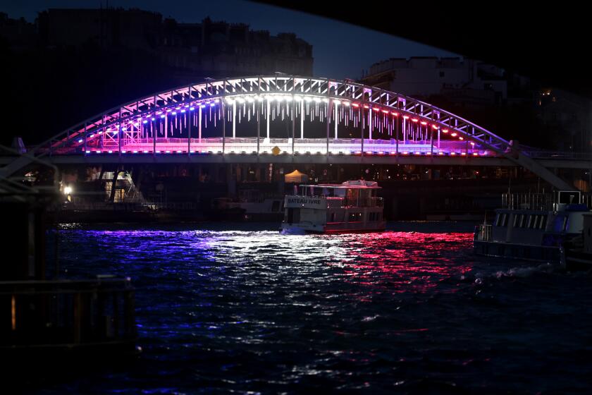 PARIS, FRANCE July 23, 2024-A bridge is lit along the Seine River days before the Olympics in Paris, France Tuesday. Wally Skalij/Los Angeles Times)