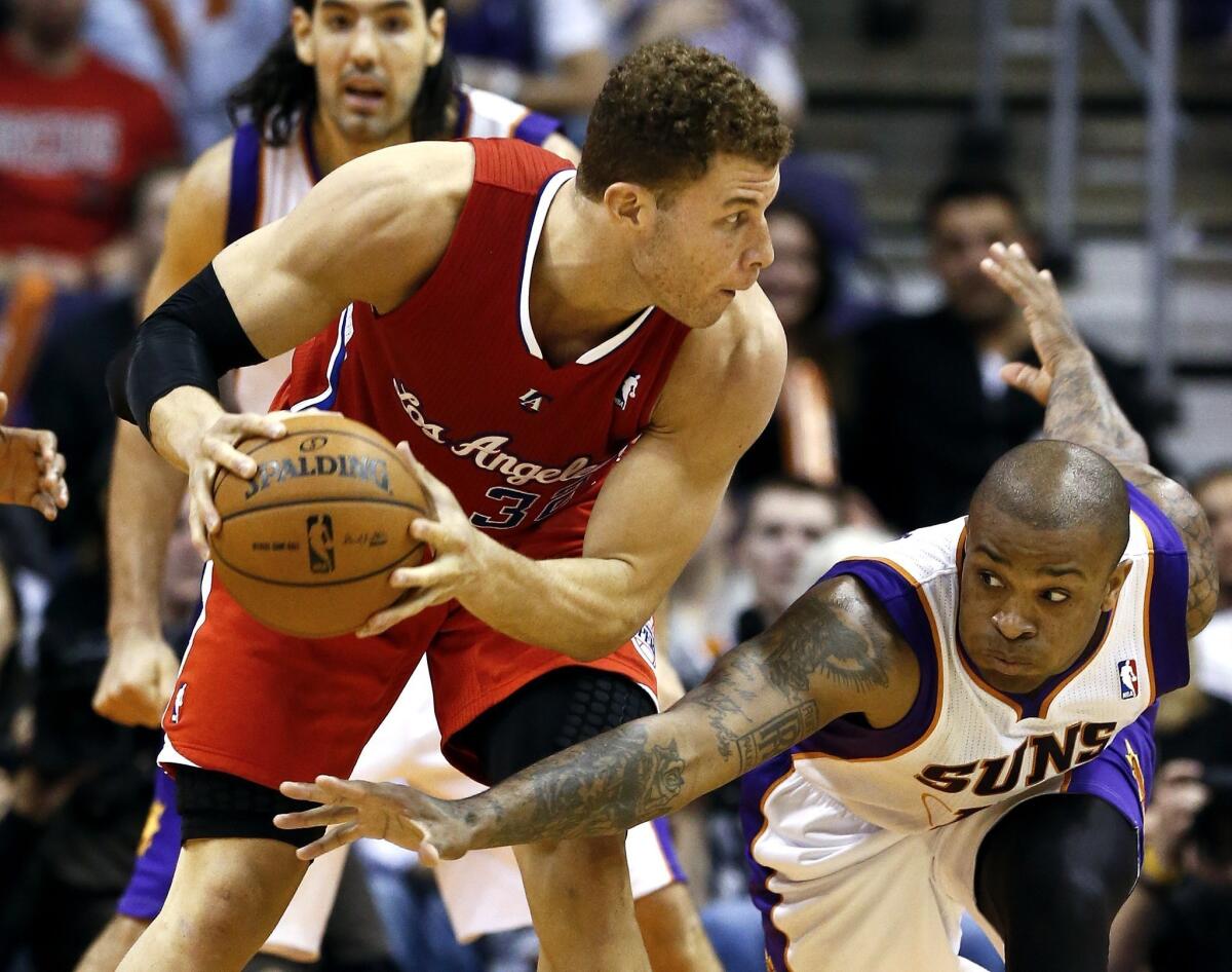 Clippers power forward Blake Griffin tries to protect the ball from the steal attempt of Suns swingman P.J. Tucker in the second half.
