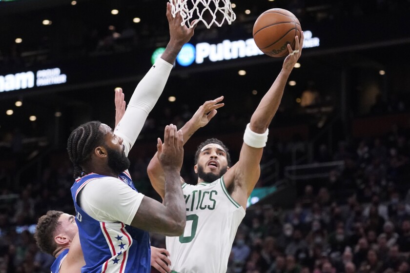 El alero de los Celtics de Boston Jaysum Tatum ataca el canasto ante el pívot de los 76ers de Filadelfia, Andre Drummond, en la primera mitad del juego del miércoles 1 de diciembre de 2021, en Boston. (AP Foto/Charles Krupa)