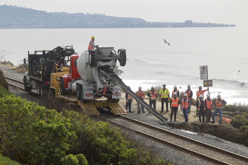 Workers repair the site of a bluff collapse next to the railroad tracks, which was caused by a washout from the recent rains, in Del Mar on Saturday, November 30, 2019 in Del Mar, California.
