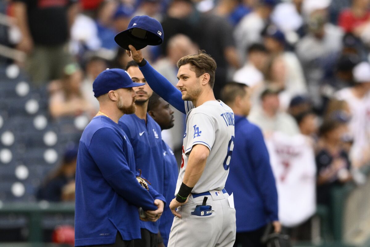 Dodgers' Trea Turner doffs his cap to the crowd as he is recognized with a tribute video before a game.