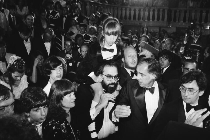 FILE - American director Francis Ford Coppola, center, carries his daughter Sofia, 8, through the crowd after the formal presentation of the U.S. film "Apolalypse Now", at the Cannes International Film Festival in France on May 19, 1979. His son Gian Carlo, 15, and his wife Ellie are left. Coppola is back at Cannes with his latest film "Megalopolis." (AP Photo/Jean-Jacques Levy, File)