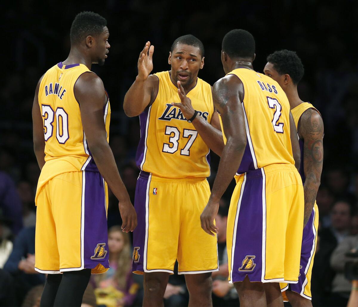 Metta World Peace (37) instructs his Lakers teammates Julius Randle (30), Louis Williams (23) and Brandon Bass (2) during the first half of a game against the Warriors on Jan. 5.