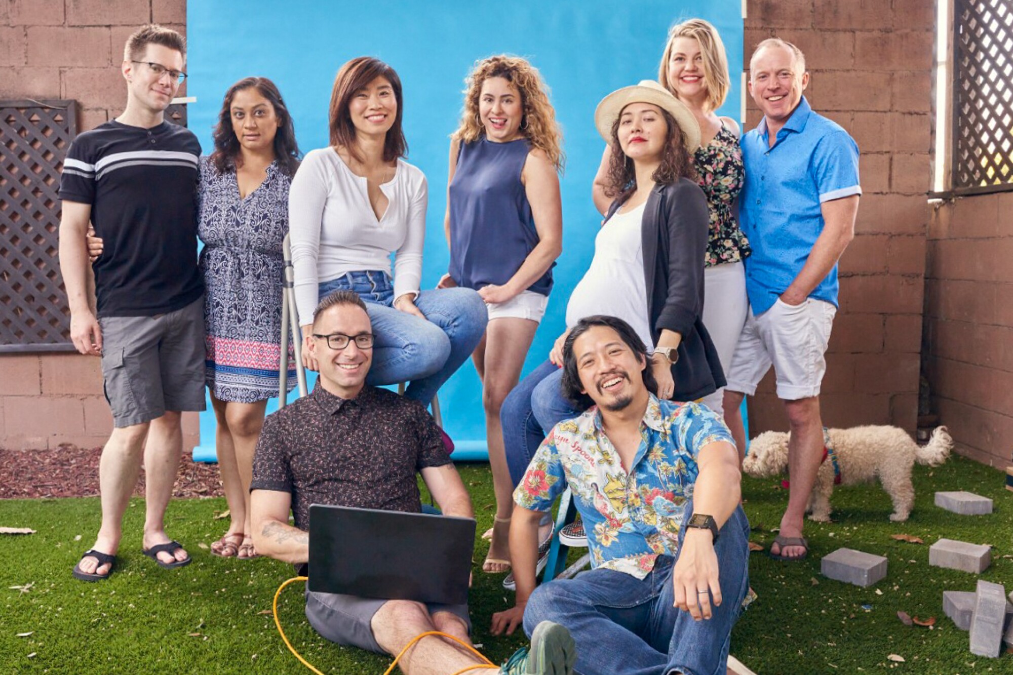 A group of people pose for a photo in a backyard.