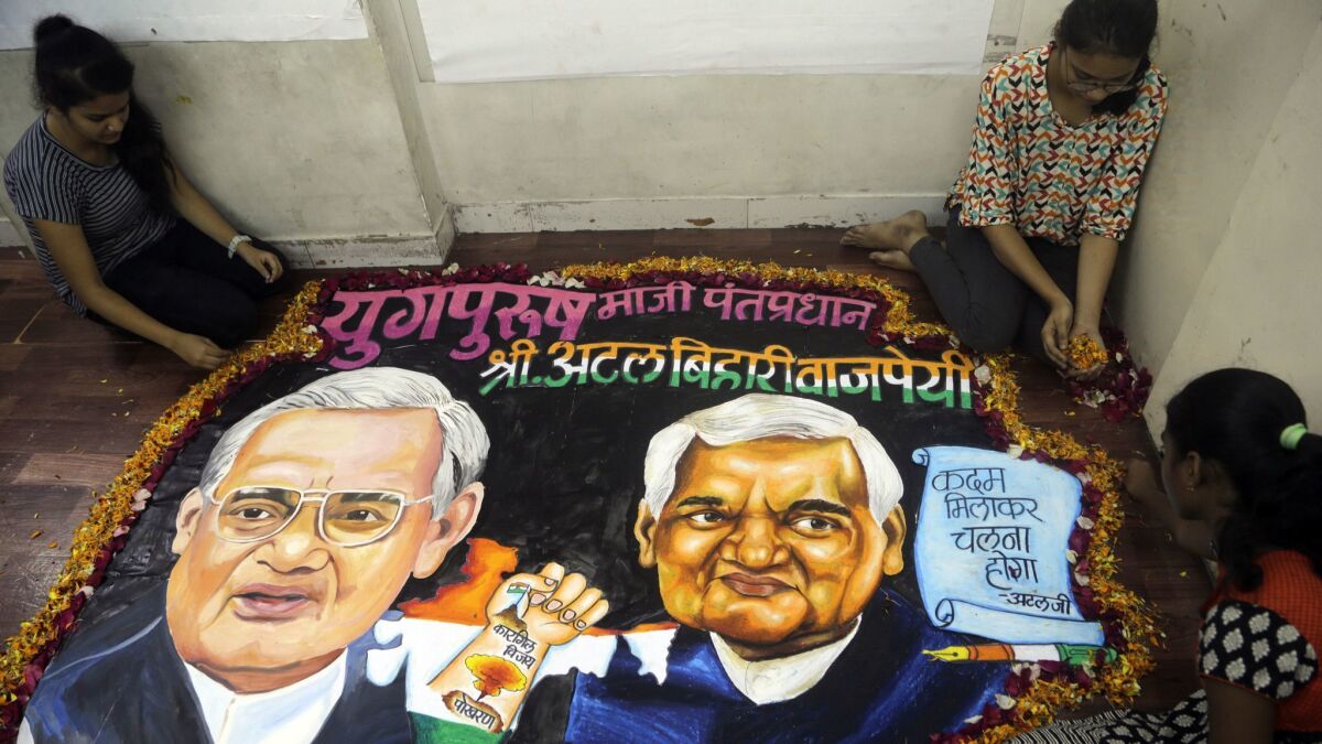 Students from an art school place flower petals around a painting of former Indian Prime Minister Atal Bihari Vajpayee in Mumbai, India, on Thursday.