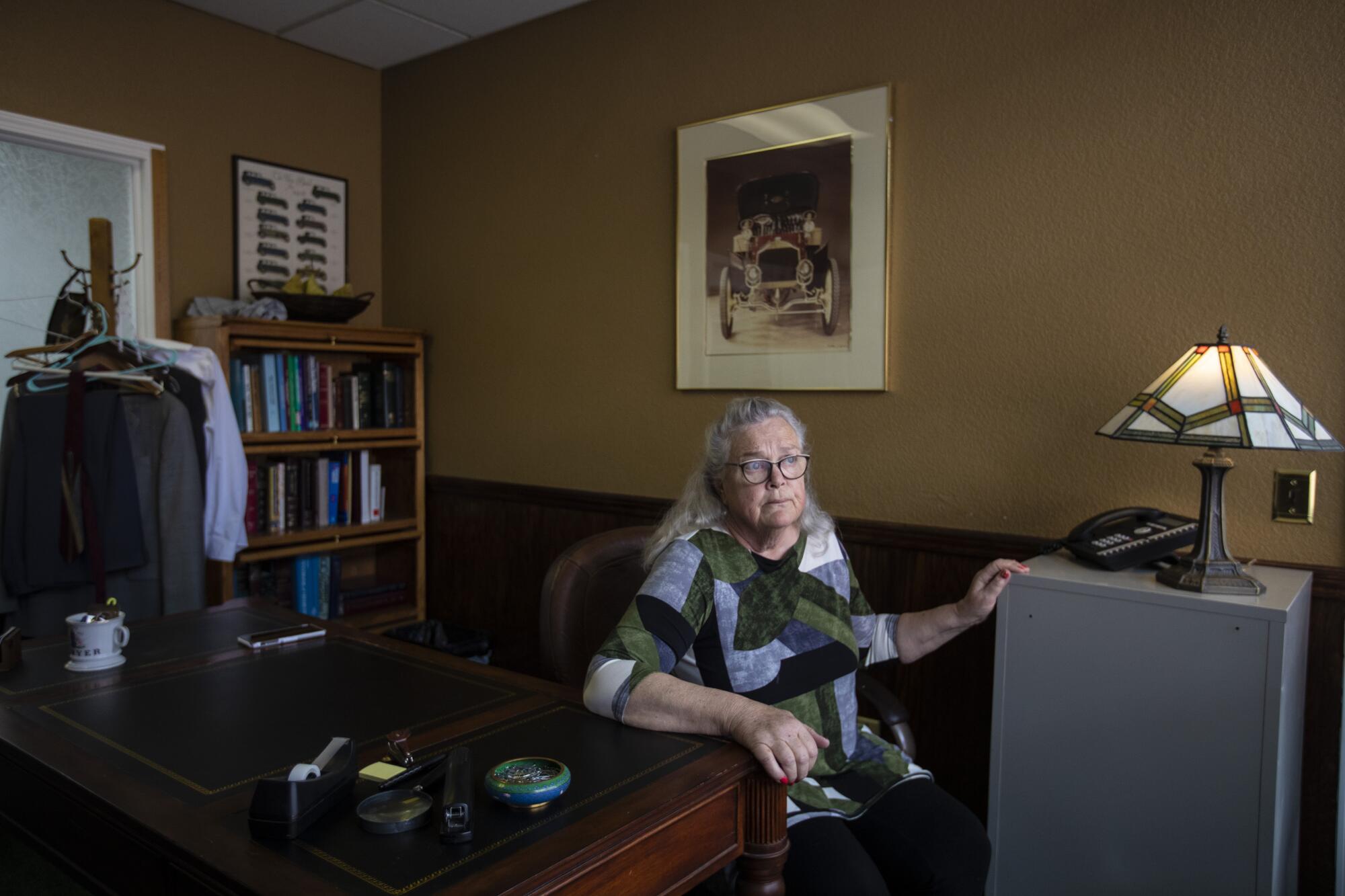 Georgia DeFilippo, wife of Frank Carson, sits at a desk in his office.