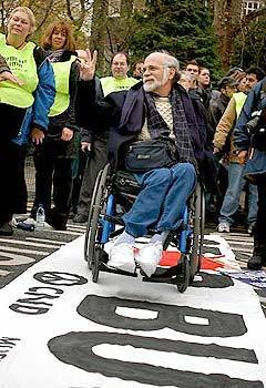 U.S. peace activist and Vietnam veteran Ron Kovic rolls his wheelchair over a banner condemning President Bush before demonstrators began their march through the streets of central London.