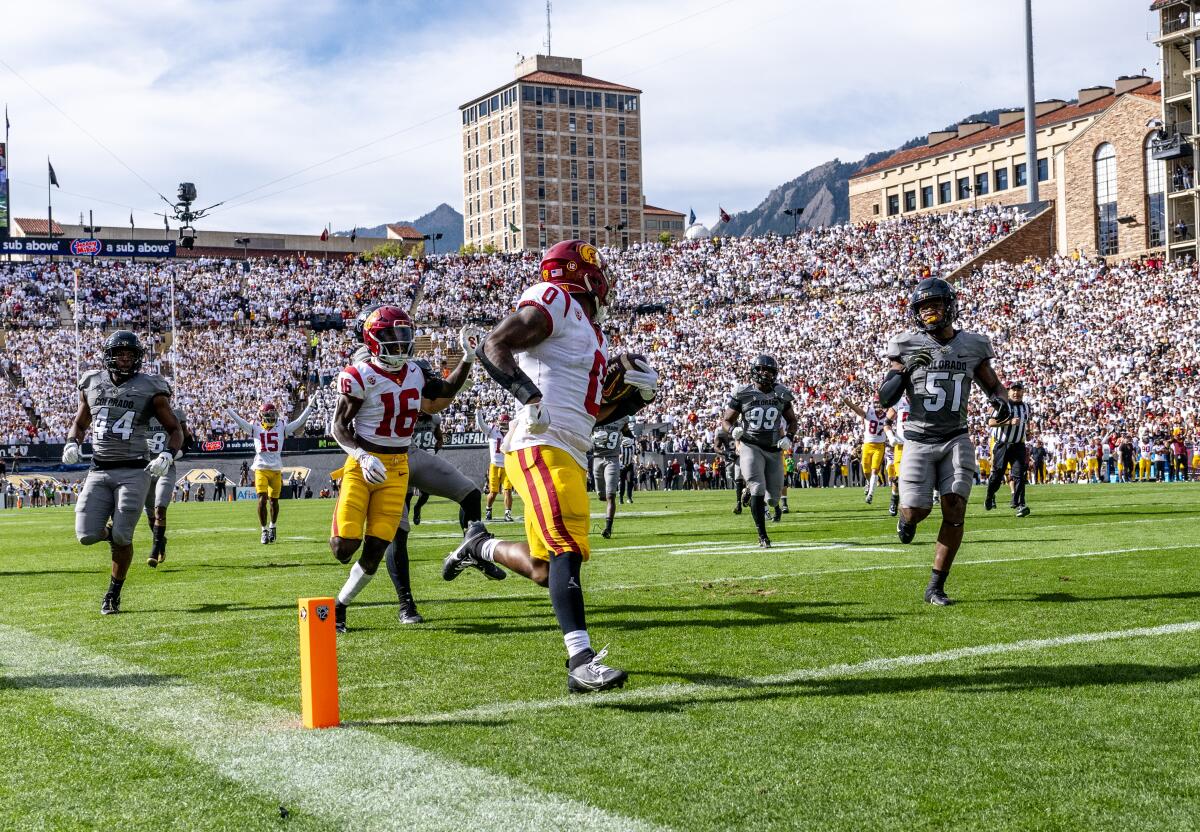 USC running back MarShawn Lloyd looks back at Colorado defenders as he approaches the goal line on a scoring run.