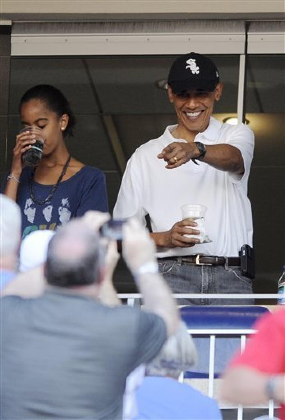 President Barack Obama, wearing a White Sox baseball cap, points to the crowd as he attends a baseball game between the Washington Nationals and the Chicago White Sox, Friday, June 18, 2010, in Washington. (AP Photo/Nick Wass)
