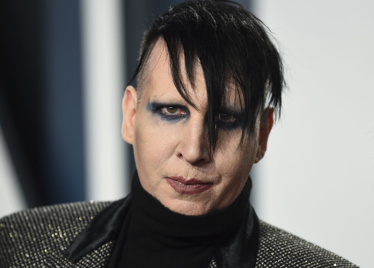 FILE - Marilyn Manson arrives at the Vanity Fair Oscar Party on Feb. 9, 2020, in Beverly Hills, Calif. An attorney has entered a not guilty plea on behalf Manson, who is accused of approaching a videographer at his 2019 concert in New Hampshire and allegedly spitting and blowing snot on her. A case status hearing is scheduled for Dec. 27. (Photo by Evan Agostini/Invision/AP, File)
