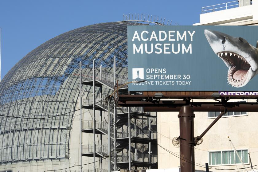 LOS ANGELES, CA - SEPTEMBER 13: A billboard announces the opening date of the Academy Museum of Motion Pictures. Renzo Piano brings new life to a storied May Co. building and creates a new icon for Los Angeles in the form of the Geffen Theater. Photographed at Academy Museum of Motion Pictures on Monday, Sept. 13, 2021 in Los Angeles, CA. (Myung J. Chun / Los Angeles Times)