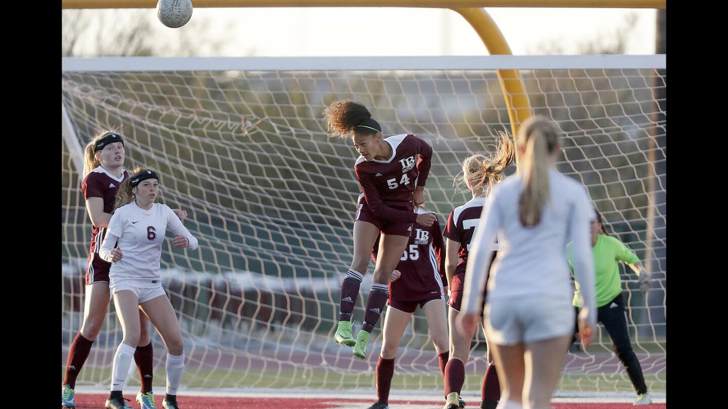 Laguna Beach Highâ€™s Reilyn Turner, center, heads the ball away from the Breakers' goal during the first half against Paloma Valley in the quarterfinals of the CIF Southern Section Division 4 playoffs on Friday at Paloma Valley High School.