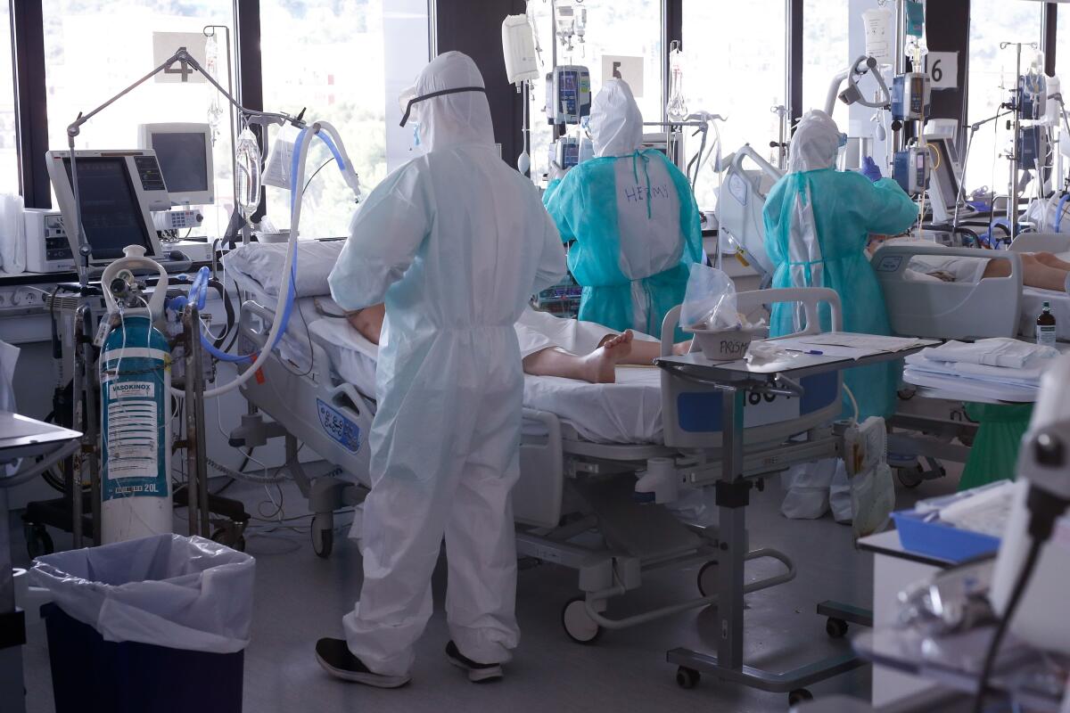 Healthcare workers wearing protective suits tend to COVID-19 patients at the Vall d'Hebron hospital in Barcelona, Spain. The country is among those hardest-hit by the coronavirus.