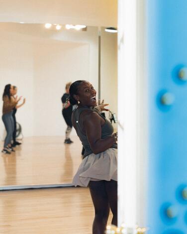 Women in a dance studio reflected in the mirrored wall